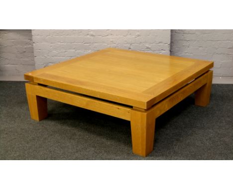 Heal light oak coffee table of large proportions raised on tapering square supports.