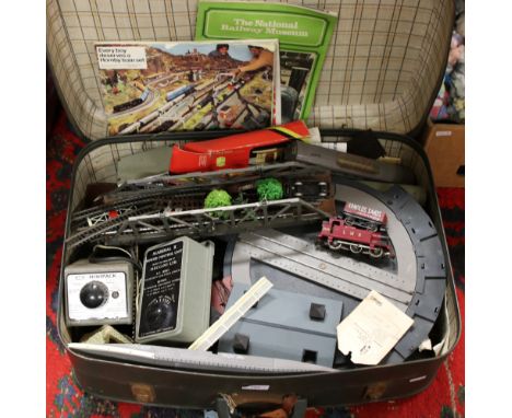 A vintage suitcase and contents of Hornby oo gauge railway to include track, transformers, buildings and rolling stock etc.