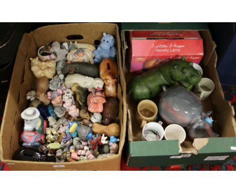 Two boxes of hippo ornaments along with mugs, badges and a boxed novelty lamp.