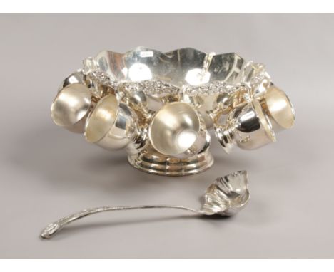 A silver plate punch set to include bowl, eight cups and serving ladle.