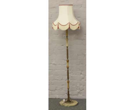 A brass and onyx standard lamp with cream fabric shade.