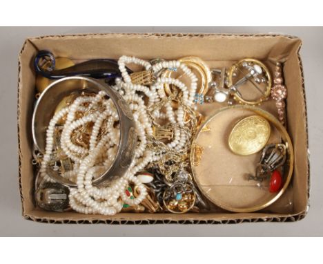 A box of costume jewellery to include gilt brooches, yellow metal bangle, pendants etc.