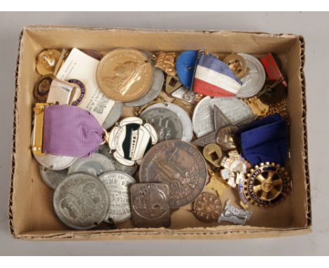 A box of medals and enamel badges.