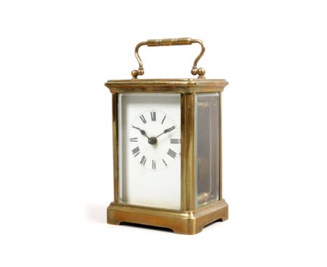 A French brass and glass carriage clock with Roman numeral markers.