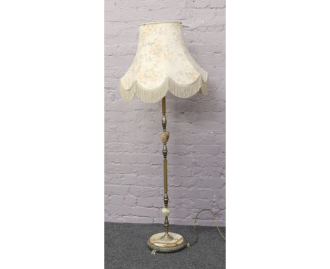 A brass and onyx standard lamp with floral shade.