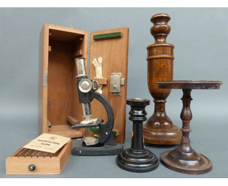 A cased microscope, cast metal stand or tazza, candlestick etc