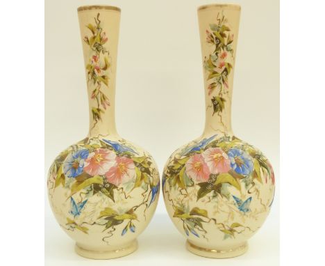 A pair of Victorian glass bottled vases with enamel decoration of flowers and butterflies on a cream ground, 38cm tall. 