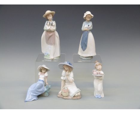 Five Nao figurines comprising a girl kneeling with flower basket, two girls with puppies, a girl with a bird and a further ex