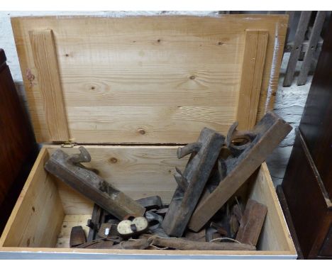 A large wooden chest containing a large collection of wooden vintage planes, bows, saws etc including brass mounted examples,
