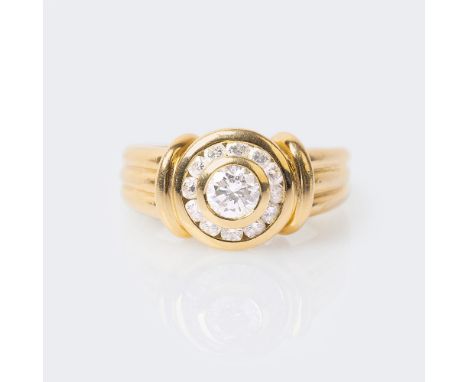 Solitär-Brillant-Ring. 18 kt. GG, gest. Kannelierte Ringschiene, schauseitig in Zargenfassung der Solitär im Brillantschliff 