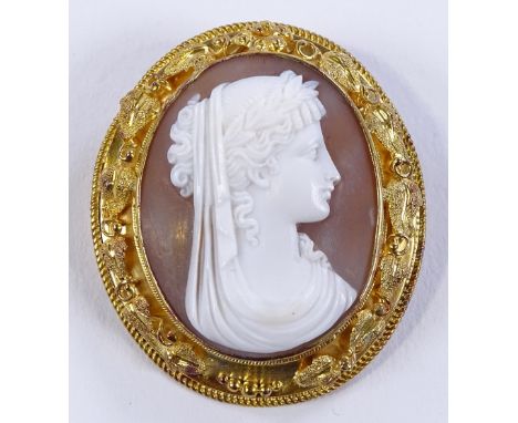 A relief carved cameo brooch, depicting a Classical portrait, in unmarked yellow metal frame with raised leaf surround, brooc