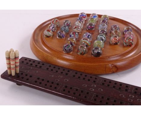 A Victorian solitaire board with hand blown marbles, together with a Victorian cribbage board and pegs