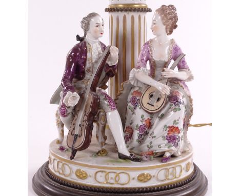 A 19th century Continental porcelain table lamp, surmounted by musician figures, converted to electric, overall height 40cm