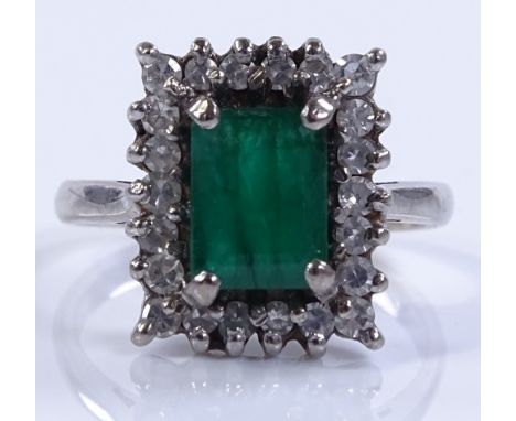 An 18ct white gold emerald and diamond cluster ring, emerald-cut emerald approx 1.36cts, setting height 14.3mm, size M, 4.9g