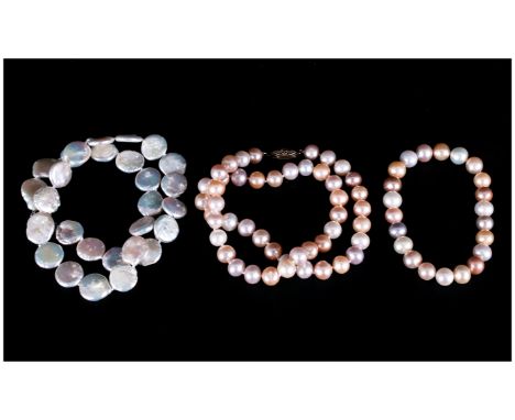 Two Various Freshwater Pearl Necklaces comprising a strand of white coin pearls and a strand of white, peach and lilac pearls