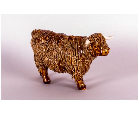 A Signed Ceramic Figure of a Highland cow, stands 4 inches high.