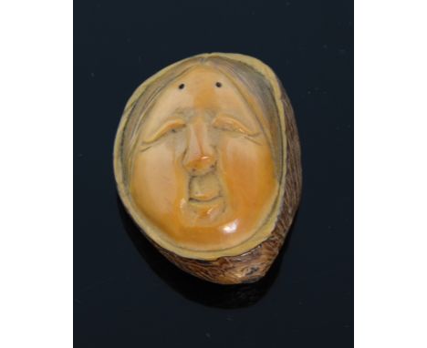 A Japanese boxwood Netsuke carved like a walnut of 'The Blind Masseuse' signed