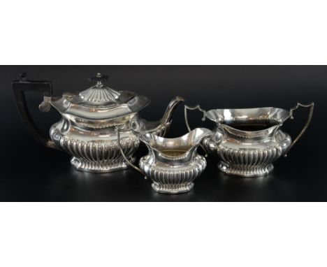 Edward VII silver three piece tea service, comprising teapot, cream jug and sugar bowl, of serpentine form with half-gadroone