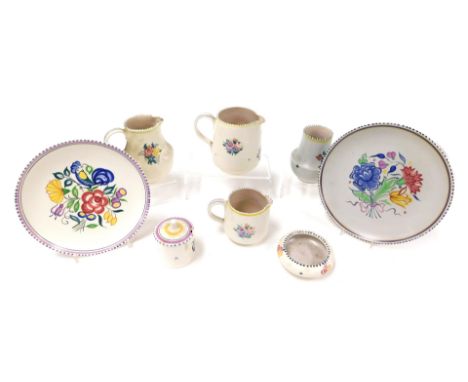 A group of 20thC Poole pottery, traditionally decorated with flowers, comprising three jugs, two plates, circular dish, vase 