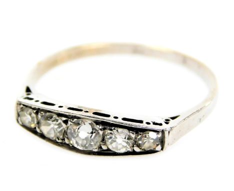 An early 20thC diamond five stone ring, channel set in white metal, approximately ¼ct, size M, 1.1g all in.