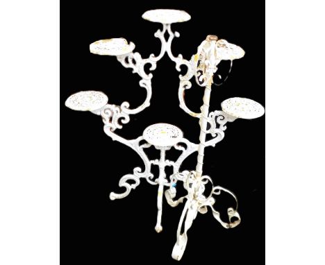 A cast iron cream painted stand, with a set of six pierced plateaus, each for garden urns, etc., on a pierced scrolling base,