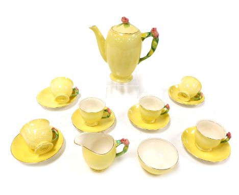 An early 20thC Royal Winton pottery part coffee service, yellow ground, with rose moulded handles and knop, printed marks, co