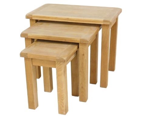 A nest of three light oak tables, of plain form, the largest 68cm wide. 