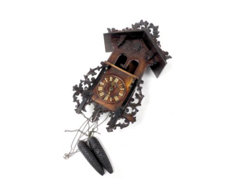 A late 19thC continental stained pine cuckoo clock, the dial bearing Roman numerals, with a carved architectural case, with f