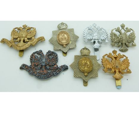 Seven British army 1st King's Dragoon Guards metal cap badges including an all brass example, one by Firmin