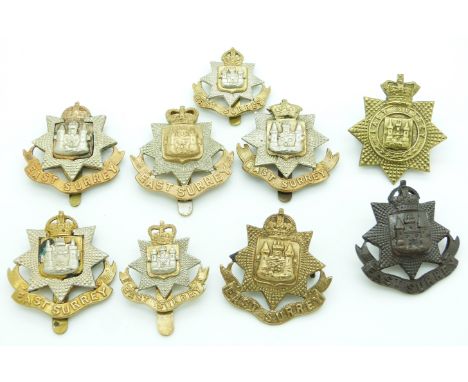 Nine British Army East Surrey Regiment metal cap badges, one by Buttons Ltd
