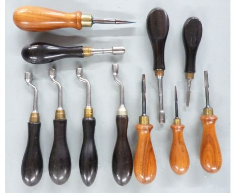 Eleven gun tools comprising flat head screwdrivers and nipple keys, all with wooden handles.&nbsp;
