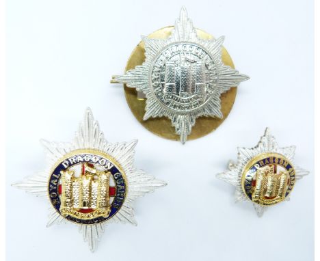 Three British Army Royal Dragoon Guards metal badges including gilt and enamel examples