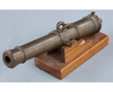 A brass table lighter in the form of a cannon on wooden base, 27.5cm long.&nbsp;