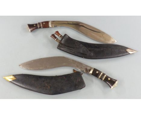 Two kukris in scabbard, one marked to blade The Army Traders India, length of longer 45cm