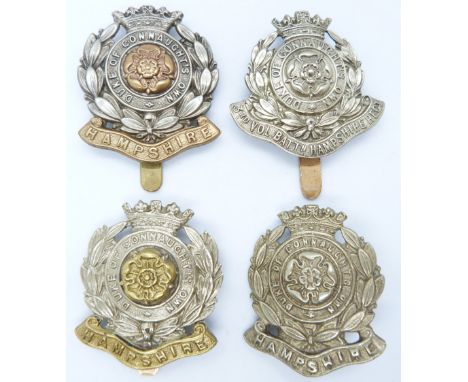 Four British Army Hampshire Regiment metal cap badges including a 3rd Volunteer Battalion example