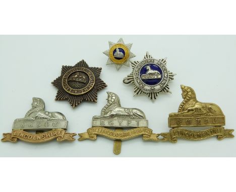 Six British Army Lincolnshire Regiment metal cap badges including an officer's gilt and enamel example