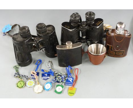 Two pairs of binoculars, one by Pancrama 10x50, the other 7x50, with paper and enamel racecourse badges, two hip flasks and a