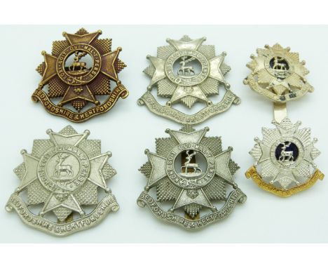 Six British Army Bedfordshire and Hertfordshire Regiment metal cap badges including an officer's gilt and blue enamel example