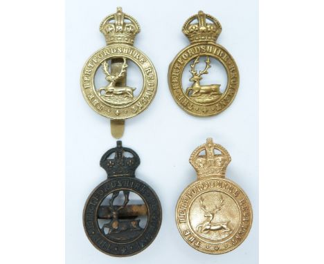Four British Army Hertfordshire Regiment metal cap badges including a non voided example