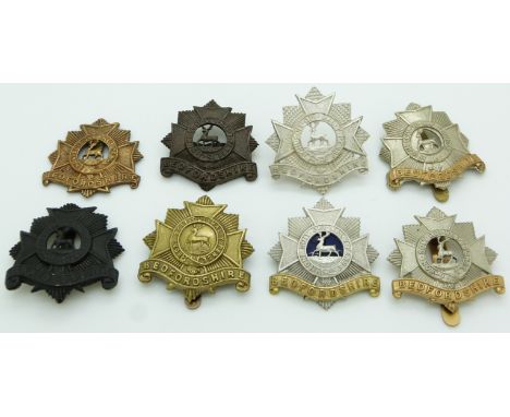 British Army Bedfordshire Regiment metal cap badges including an example with blue enamel centre