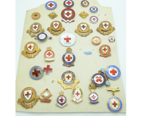 A carded display of thirty two&nbsp;Red Cross enamel badges including county examples for Surrey, Devon, Gloucester and Brist