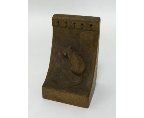 In the style of Robert 'Mouseman' Thompson, a single carved wood bookend with mouse carving.