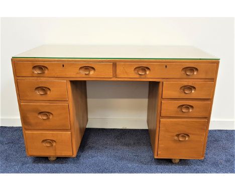 ERCOL LIGHT ELM KNEEHOLE DESKwith an arrangement of eight drawers, on later casters, 118cm wide 