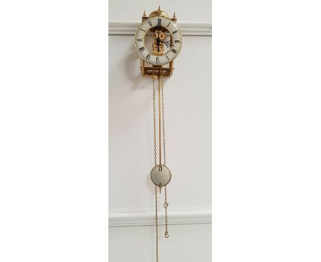 GERMAN HERMLE BRASS LANTERN STYLE CLOCKwith a circular bell above a cream coloured chapter ring with Roman numerals, with a 3