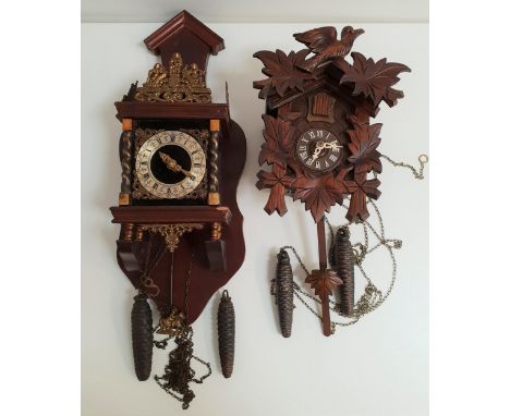 BLACK FOREST CUCKOO CLOCKin a stained pine case with a circular dial with Roman numerals, two weights and pendulum, together 