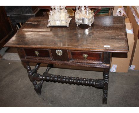 An Antique oak side table, the over hanging top above a single moulded front drawer, raised on bobbin turned supports, termin