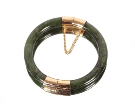 A jade and yellow metal mounted bangle