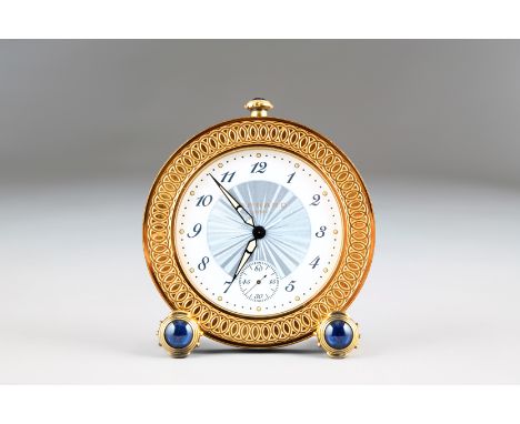 Boxed Limited Edition gilt metal travel alarm clock by Garrard, London, circular form with sapphire cabochons to feet and win