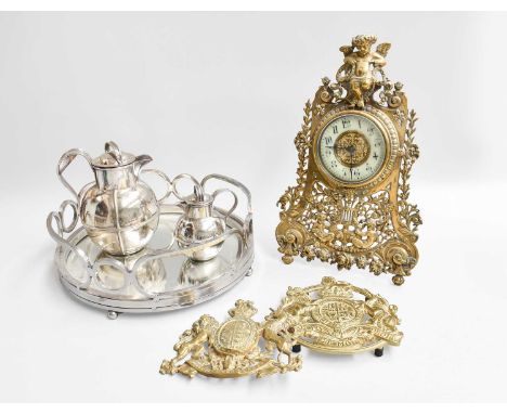 A Pierced Brass Strut Timepiece, surmounted by a young faun, together with a brass helmet plate with coat of arms, stamped He