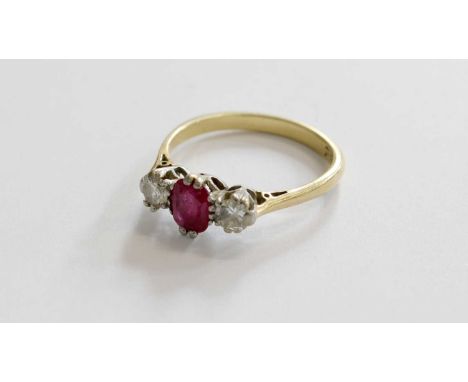 A Ruby and Diamond Three Stone Ring, the oval cut ruby flanked by round brilliant cut diamonds in white claw settings, to a y